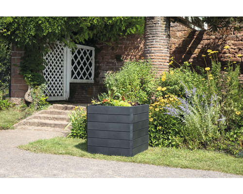 Vierkante plantenbak van kunststof met planten in de tuin.