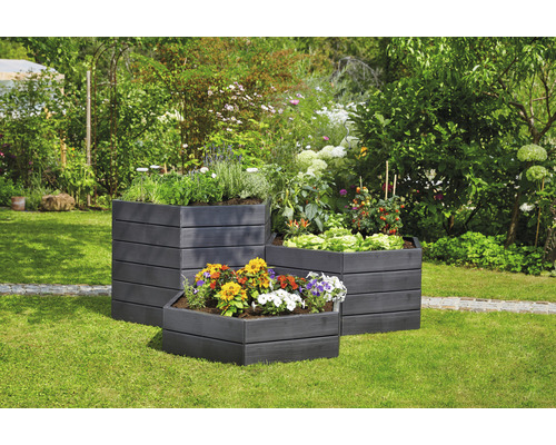 Drie houten plantenbakken met planten in de tuin