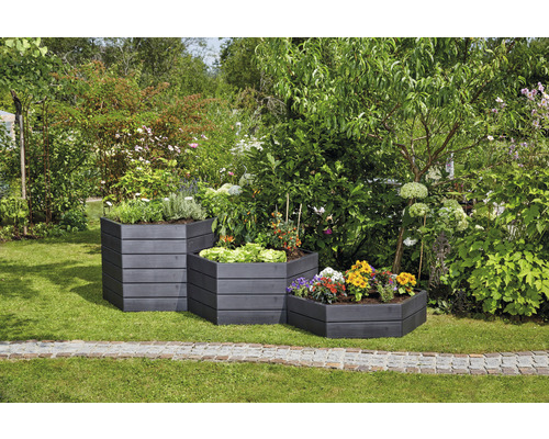 Drie trapsgewijze beplante houten plantenbakken in de tuin.