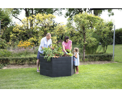 Familie plant een verhoogde tuinbak in de tuin.
