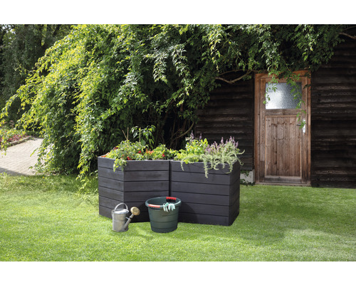 Scene met twee houten plantenbakken, een emmer, een gieter en planten in de tuin