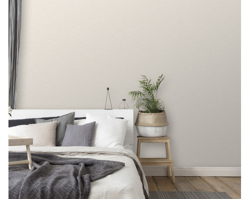 Slaapkamer met bed, kussens, deken, potplant en nachtkastje