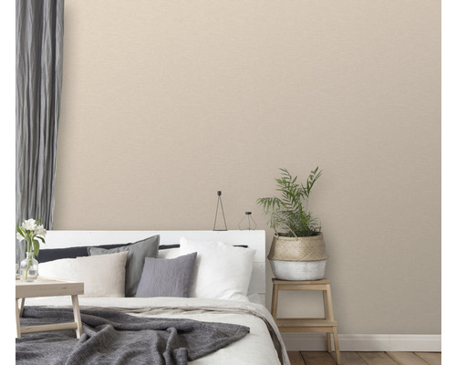 Slaapkamer met beige textielbehang, bed en kamerplant