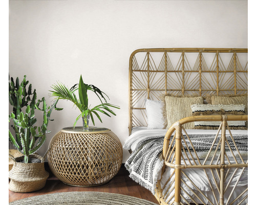 Slaapkamer in bohemien stijl met bamboe bed, bijzettafel en kamerplanten