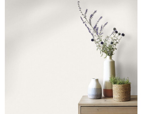 Decoratieve vazen met bloemen op een houten tafel voor een muur