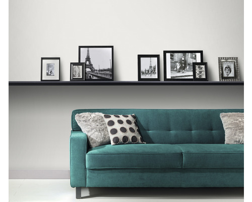 Kamerdecoratie met bank, plank en fotolijsten