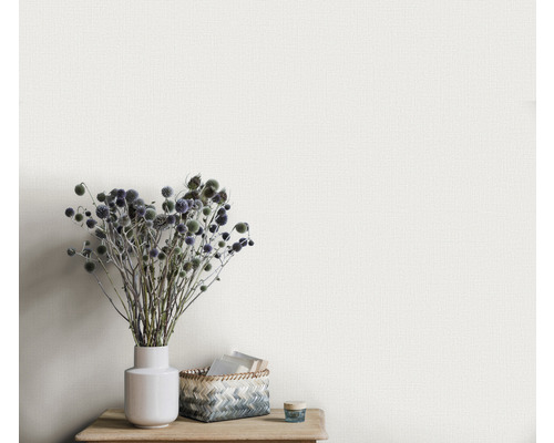 Close-up van een gestructureerd behang met een vaas en decoratie op een houten tafel