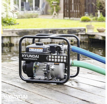 Hyundai waterpomp met slangen op houten planken aan het water