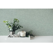 Decoratieve scène met behang, kaars en plant op een tafel
