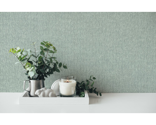 Decoratieve scène met behang, kaars en plant op een tafel