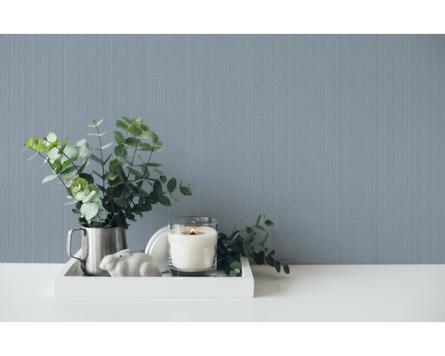 Decoratieve scène met behang, kaars en eucalyptus op een dienblad.