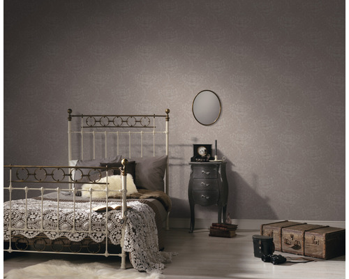 Slaapkamer met bed, nachtkastje en patroonbehang voor een gezellige sfeer.