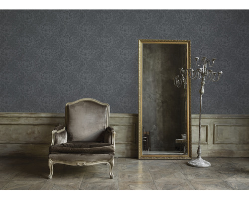 Woonkamer met bloemenbehang, fauteuil, spiegel en kandelaar