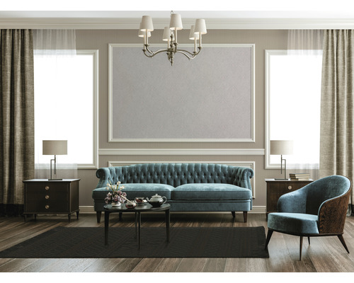 Woonkamer met bank, fauteuil, tapijt, tafel en decoratie