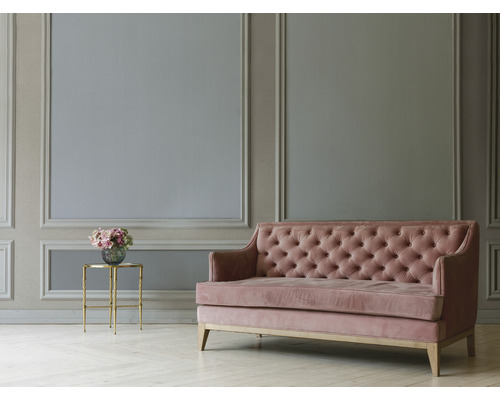 Woonkamer met wandpanelen, sofa met knoopdecoratie en bijzettafel met boeket