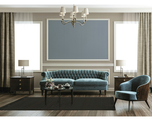 Woonkamer met bank, fauteuil, tafel, vloerkleed en decoratie