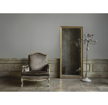 Fauteuil, spiegel en kandelaar in een kamer in vintage stijl