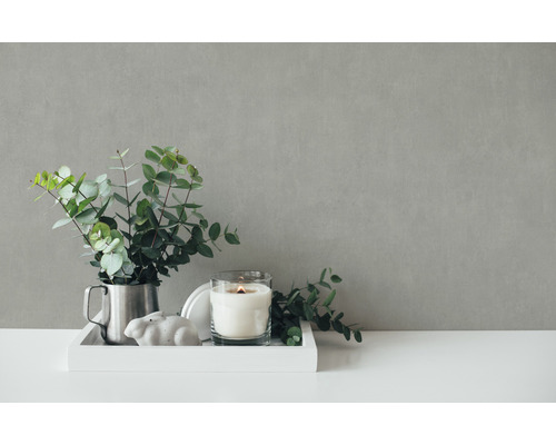 Decoratieve scène met eucalyptus in een kan, kaars in glas en konijnenfiguur op een dienblad