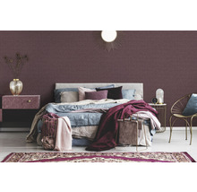 Slaapkamer met bed, nachtkastje en decoratief wandbehang.