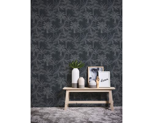 Scene met een wandbekleding met palmmotief, een houten tafel, vazen en decoratieve objecten.