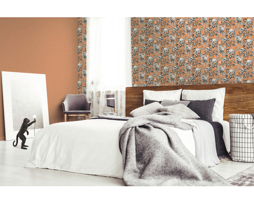 Slaapkamer met bed en behang met apenmotieven