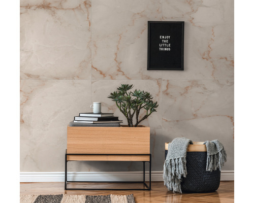 Wanddecoratie met marmeren tegels in lichte kleurstelling, gecombineerd met een houten kast op metalen frame en decoratieve accessoires.