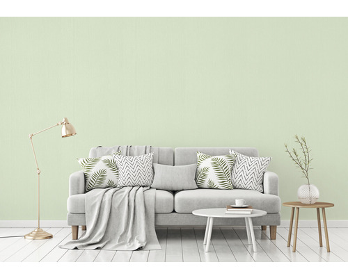 Woonkamer met bank, kussens, tafel en vloerlamp