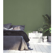 Slaapkamer met bed, nachtkastje en groene muur