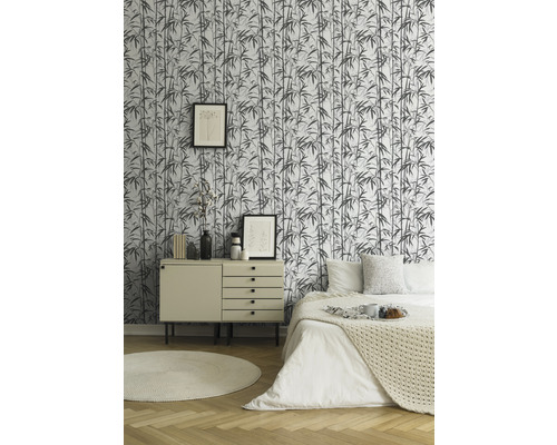 Slaapkamer met bamboe behang, commode, bed en decoraties voor een heldere en georganiseerde sfeer