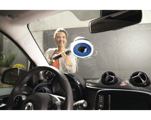 Vrouw reinigt autoruit met een borstel