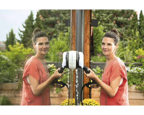 Vrouw reinigt ramen met een reinigingsborstel