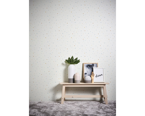 Decoratief behang met stippenpatroon in een kamer met een klein tafeltje waarop vazen en fotolijsten staan.