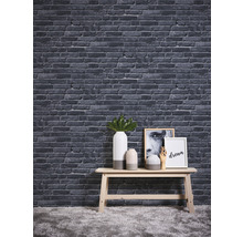 Decoratief behang met steeneffect boven een tafel met vazen en schilderijen.