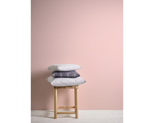 Decoratieve kussens op een kruk voor een muur