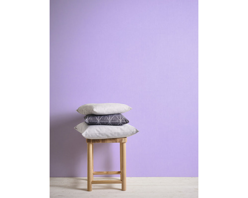 Decoratieve kussens gestapeld op een kruk voor een wand