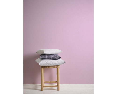 Decoratieve kussens op een kruk voor een wand