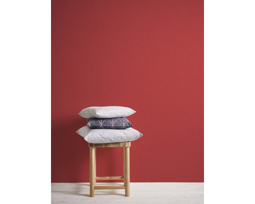 Decoratieve kussens op een houten kruk voor een muur