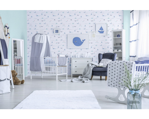 Lichte kinderkamer met babybedjes, commode, fauteuil en decoratie in maritieme stijl