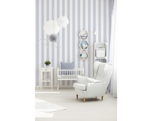 Babykamer met gestreept behang, kinderbed en fauteuil
