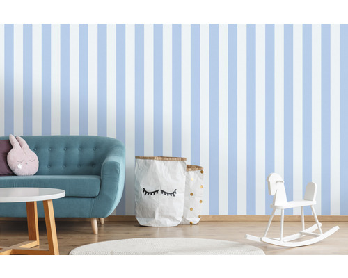 Kinderkamer met gestreept behang, bank, tafel, speelgoed en opbergzakken