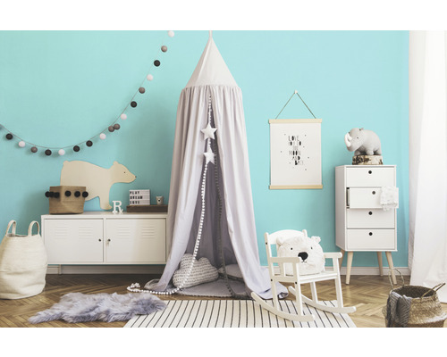 Decoratieve kinderkamer met hemelbed, schommelstoel en commode