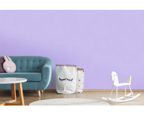 Kinderkamer met bank, tafel, speelgoed en decoratie tegen een muur