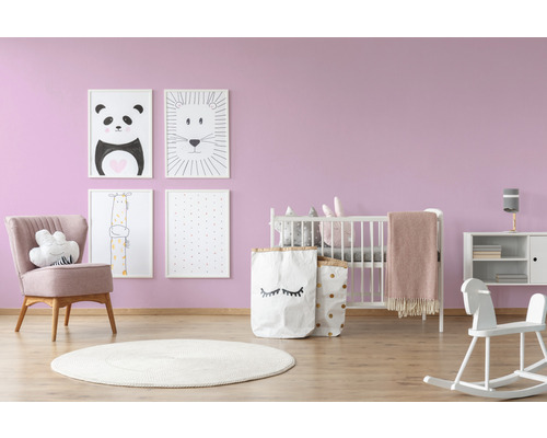 Kinderkamer met babybed, fauteuil, speelgoed en afbeeldingen aan de muur