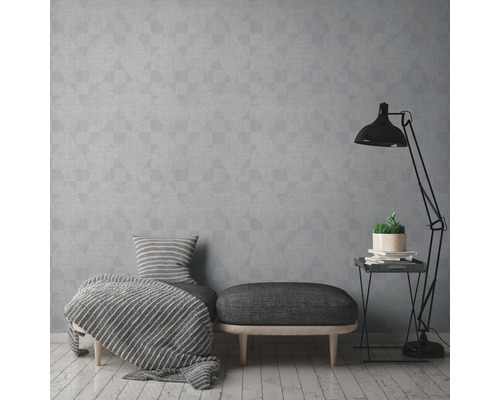 Woonkamer met grijs geometrisch behang, hocker en staande lamp