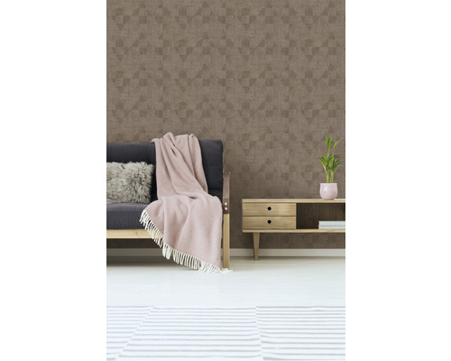 Woonkamer met patroonbehang, bank, deken en bijzettafel