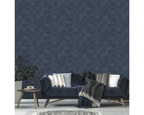 Woonkamer met patroonbehang, bank, kussens, deken en bijzettafel