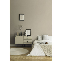 Slaapkamer met bed, commode, rond tapijt en decoratie