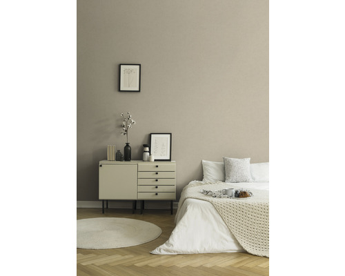 Slaapkamer met bed, commode, rond tapijt en decoratie