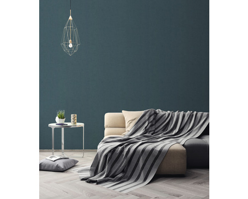 Woonkamer met bank, deken, tafel en hanglamp voor een gezellige sfeer