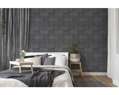 Slaapkamer met bed en donker steenlook behang op de muur